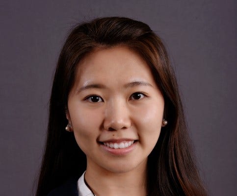 young Asian woman with long brown hair, white collar, and champagne pearl earrings