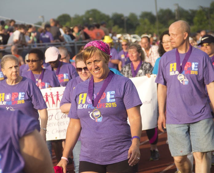 A large group of Relay For Life participants walk the track at an event